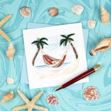 Quilled Beach Hammock Greeting Card on swirling blue background next to seashells with red pen