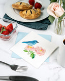 Quilled Bluebird & Peonies Greeting Card with light blue envelope on kitchen table with breakfast strawberries, hand pies, flowers, coffee, and utensils