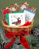 Quilled Christmas Goose Holiday Card in a basket next to Quilled Snowflake Note Card Box Set, Quilled Angel Ornaments Box Set, Quilled Snowflake Ornaments Box Set, Quilled Christmas Ornaments Box Set, and Quilled Poinsettia Ornaments Box Set, surrounded by pine needles and pine cones.