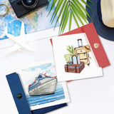 Quilled Cruise Ship Greeting Card next to Vintage Luggage Quilled Greeting Card surrounded by maps, hat, airplane sculpture