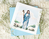 Quilled Jesus Greeting Card with light blue envelope on top of baby's breath and white lace