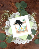 Quilled Mischievous Cat Greeting Card with light green envelope, white lace doiley, eucalyptus and baby's breath, on dark brown background