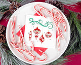 Quilled Red Christmas Ornaments Greeting Card sitting on a dish with candy canes surrounded by pine cones and pine needles.
