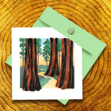 Quilled Redwood Trees Greeting Card with light green envelope on wood stump