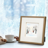 Quilled Snow Covered Trees Greeting Card in gold frame next to coffee and cinnamon in front of frosty window