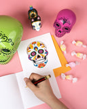 Quilled Sugar Skull Greeting Card with orange envelope with insert next to candies, sugar skulls on pick background