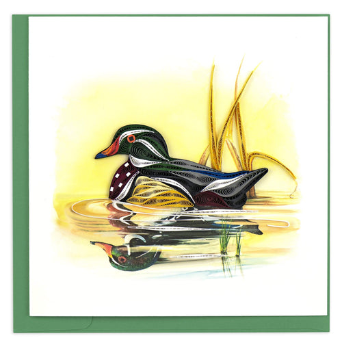 Blank greeting card of a quilled wood duck floating on lake with yellow reeds
