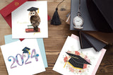 Quilled 2024 Grad Card with other graduation quilled greeting cards on table next to graduation cap and books