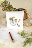 Quilled Antique High-Wheel Bicycle standing next to card insert that says "remember when..." in front of bag with flowers in it