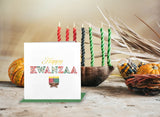 Quilled Happy Kwanzaa Card standing up with green envelope in front of candles