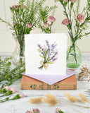Quilled Lavender Bunch Greeting Card with purple envelope on top of book surrounded by florals on white background