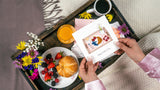 Quilled Breakfast in Bed photograph being held over breakfast in bed tray with croissant berries and florals in bed