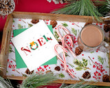 Quilled NOEL Christmas Card sitting in a Christmas tray with candy cans and hot chocolate, surrounded by pine needles and pine cones.