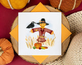 Quilled Scarecrow Greeting Card with orange envelope on red table surrounded by decorative pumpkins