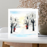 Quilled Snow Covered Trees Greeting Card standing on table in front of flowers and white background