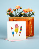 Quilled Summertime Treats Greeting Card standing with pink envelope in front of wicker purse filled with flowers on blue background