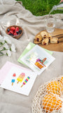 Quilled Summertime Treats Greeting Card on picnic blanket next to fruits florals and treats