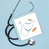 Quilled Thank You Healthcare Greeting Card laying on a stethoscope and a blue background.