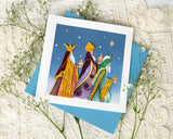 Quilled Three Wise Men Greeting Card with blue envelope on top of baby's breath and white lace fabric