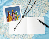 Quilled Three Wise Men Greeting Card with insert, pen, and necklace with cross on top of white lace and blue background