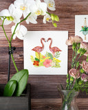 Quilled Tropical Flamingos Greeting Card on wooden wall next to white orchid and pink flowers