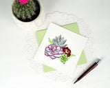 Quilled Vibrant Succulents Greeting Card with light green envelope on white doily next to pen and succulant