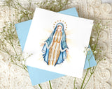 Quilled Vigin Mary Greeting Card with light blue envelope on top of baby's breath and white lace