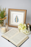 Quilled Vigin Mary Greeting Card in golden frame behind open book, white flowers, angel statues and dried flowers