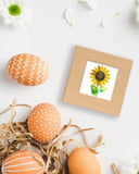Quilled Sunflower Sticky Note Pad Cover on white table next to decorated eggs and white flowers