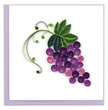 A bunch of purple grapes hanging from a green vine.