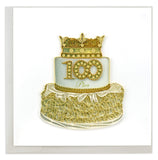 A white cake with gold adornments and a decoration that reads 100 Plus.