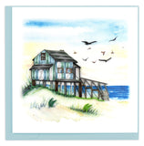Blank Quilled card of a Blue and White House on stilts on the beach.