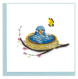 A baby bird emerging from a blue egg with a yellow butterfly.