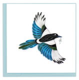 Blank greeting card of a quilled blue, black and white magpie with a key in its beak