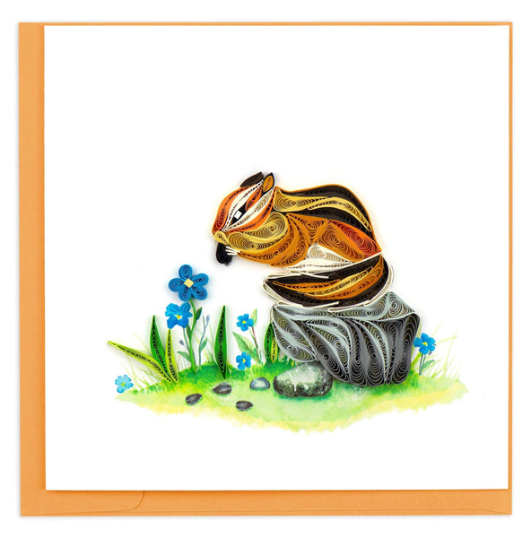 Quilled  greeting card of a chipmunk perched on gray rock nibbling seeds surrounded by blue flowers