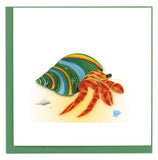 Blank quilled card of an orange Hermit Crab with a blue, green and and yellow striped shell. 