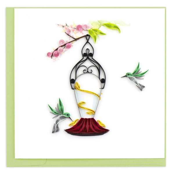 Quilled blank card of a hummingbird feeder and two green and gray hummingbirds.