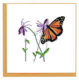 A butterfly with orange and black wings, and long antennae flying next to purple flowers.