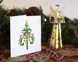 Quilled Ornate Christmas Tree card on display next to Christmas decorations.