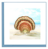 Blank greeting card of a quilled scallop shell sitting in the sand
