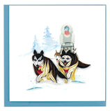 A blank greeting card of two quilled huskies pulling their musher through the snow