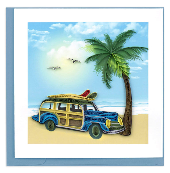 A classic blue woodie parked by a palm tree in the sun